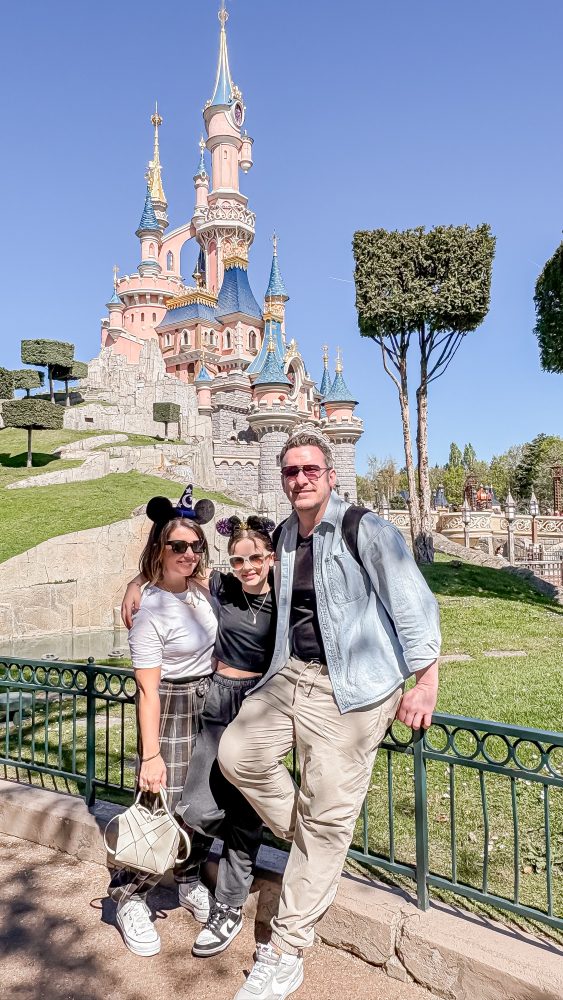 family picture in front of the iconic Disney Castle